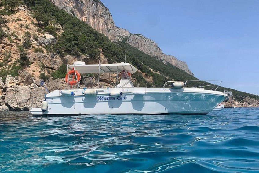 Un barco llamado 'Marebello' fondeado cerca de una costa rocosa. 4