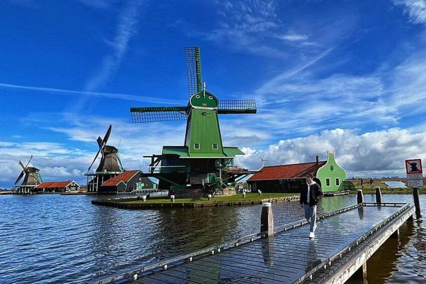 Un moulin à vent, une jetée en bois et une étendue d’eau. 1