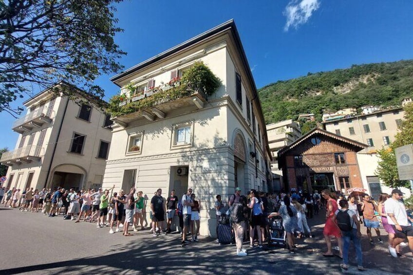 Una strada affollata con edifici storici e una collina sullo sfondo. 1