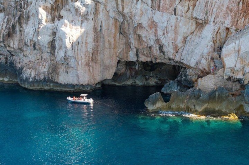 Una embarcación cerca de una costa rocosa con aguas azul cristalino. 2