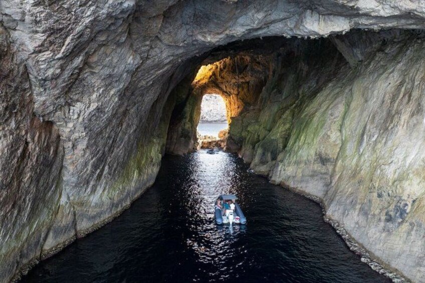 Un estrecho canal de agua que atraviesa una cueva rocosa con una barca. 4