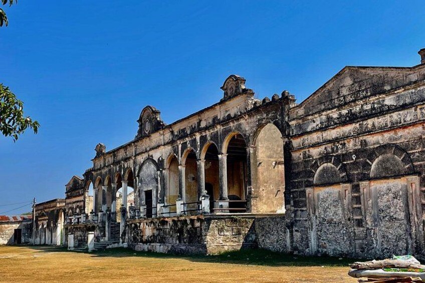 An old colonial building with arched windows and a weathered facade. 2