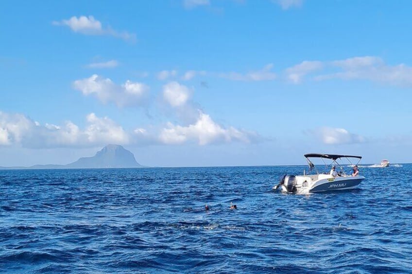 Una barca chiamata "JOPHARI" sull'oceano, con un'isola in lontananza e un'altra barca sullo sfondo. 4