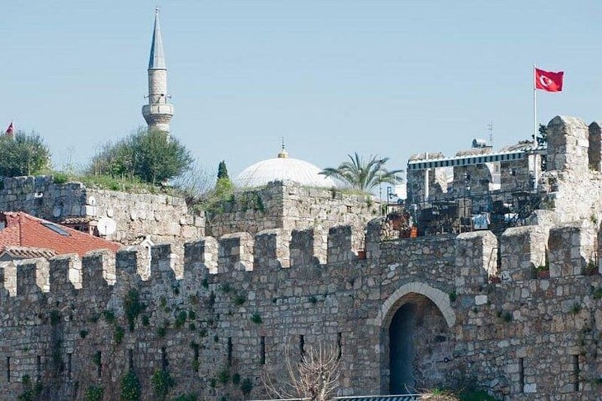 A historic stone wall with a mosque and a dome in the background. 4