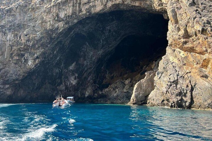 A boat near a rocky cave entrance. 5