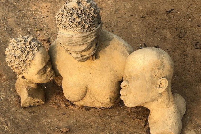 Escultura de una mujer y dos niños en un entorno natural. 1
