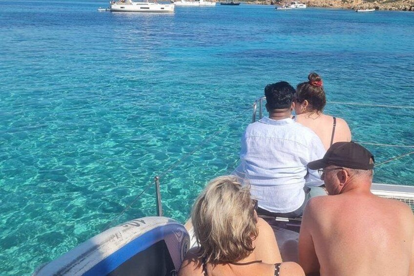 Un grupo de personas en un bote sobre aguas azules y cristalinas. 4