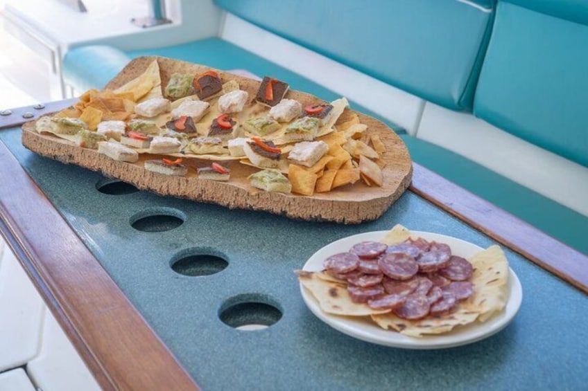 Un vassoio di stuzzichini e un piatto di salumi su un tavolo. 3