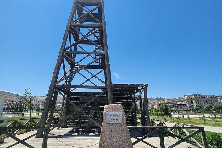 Une haute structure métallique, qui pourrait être un pont ou une tour, avec un ciel dégagé et des bâtiments en arrière-plan. 3
