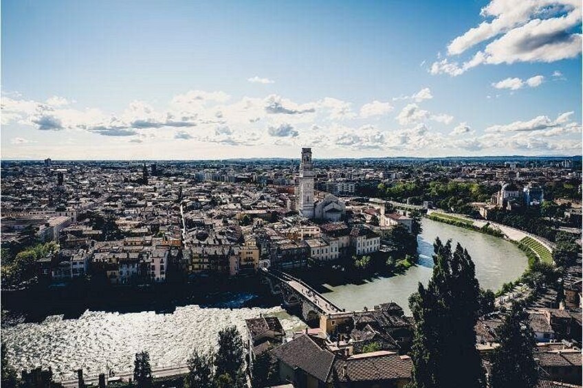 Un fiume serpeggia attraverso una città con edifici storici e una torre imponente. 2