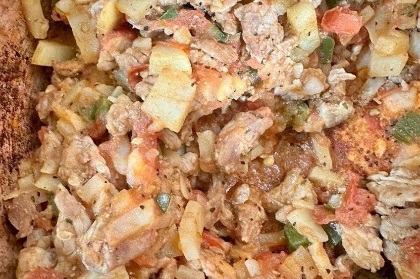 Primer plano de un plato con verduras y carne cortadas en cubos, posiblemente un guiso o cazuela. 2
