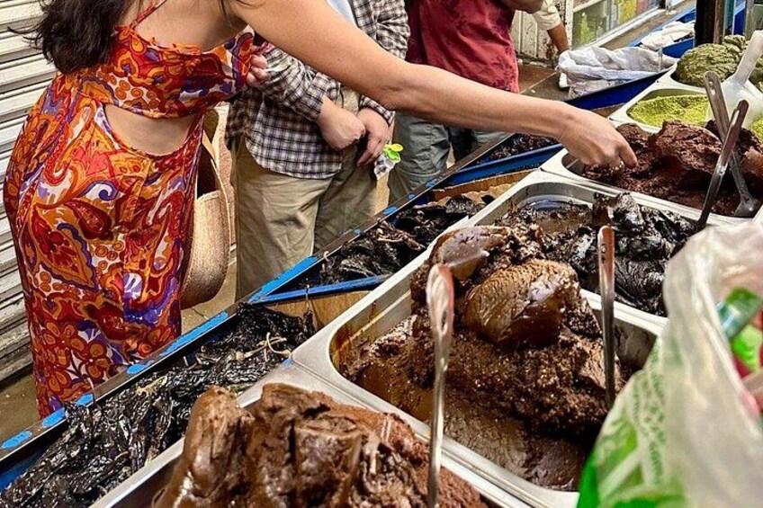 Un puesto de comida con varios platos, incluyendo lo que parece carne a la parrilla y quizás algunas verduras. 3