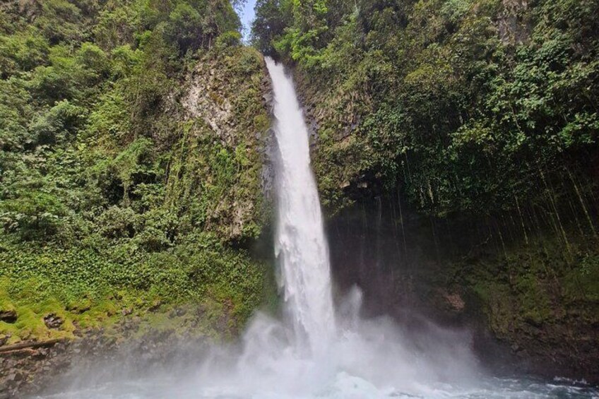 A waterfall cascading down a lush, green hillside. 4