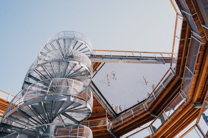 A spiral staircase with glass railings and wooden beams. 1