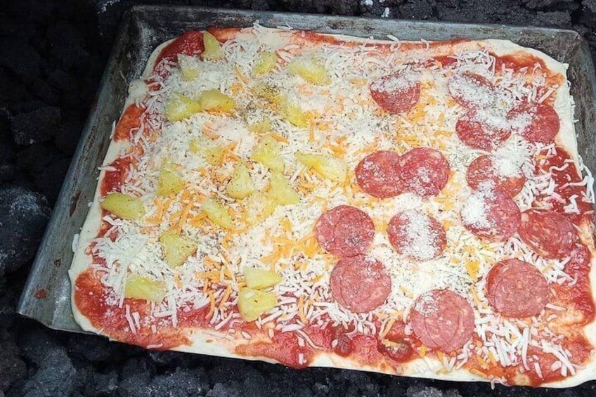 Una pizza con ingredientes sobre una bandeja para hornear. 5