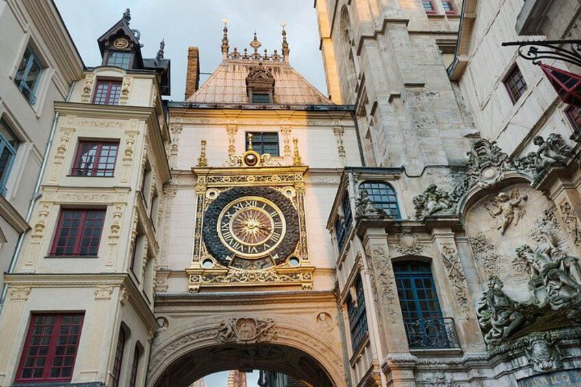 Un edificio histórico con una imponente torre de reloj, detalles arquitectónicos ornamentales y una estatua. 3