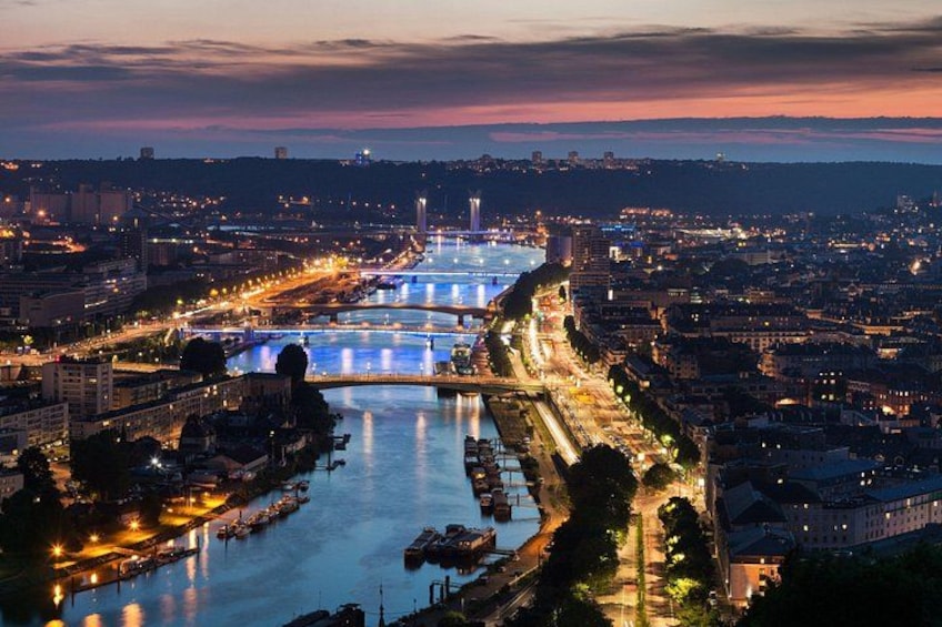 Un río con puentes y luces de la ciudad al anochecer. 2