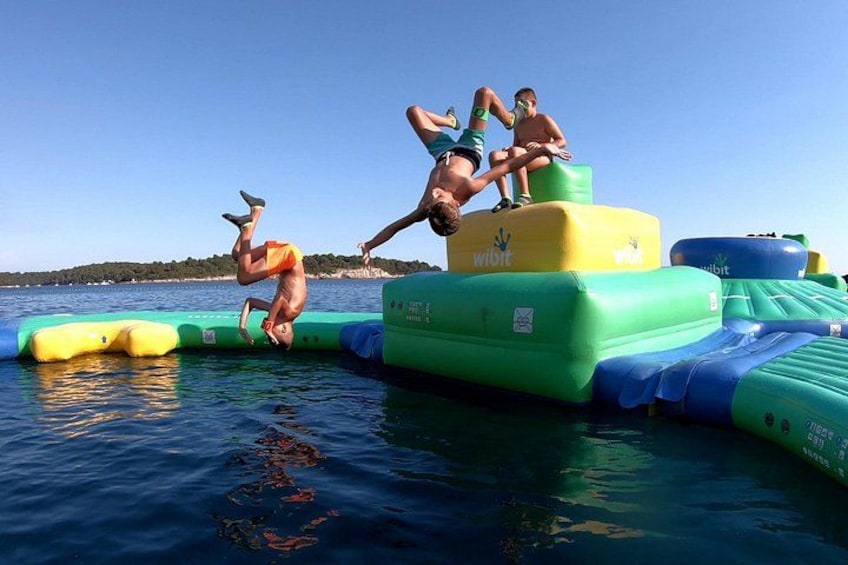 People performing acrobatics on inflatable water structures. 4