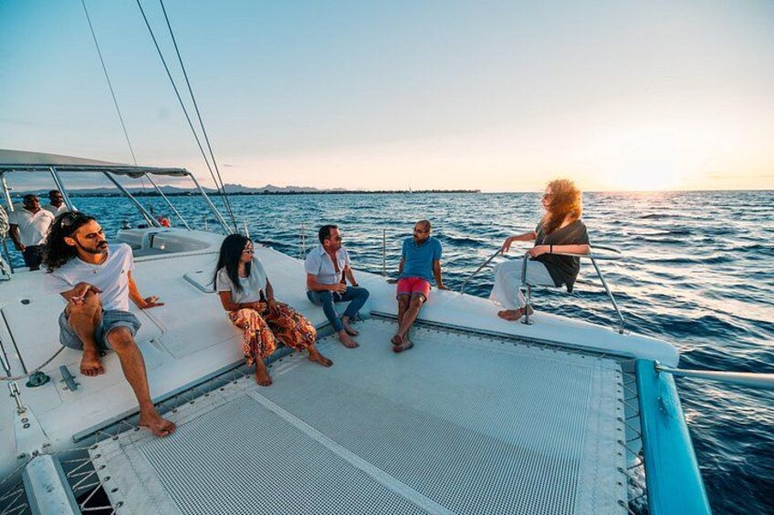 A group of people on a sailboat with a clear sky and calm sea. 5