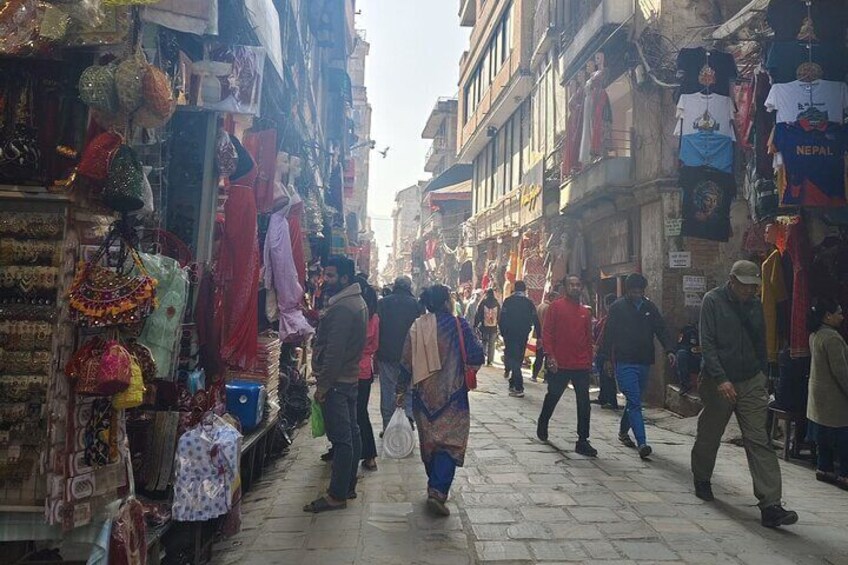 Un mercado callejero animado con gente caminando y tiendas a ambos lados. 3