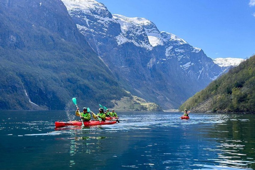 A group kayaking on a calm lake surrounded by mountains. 2