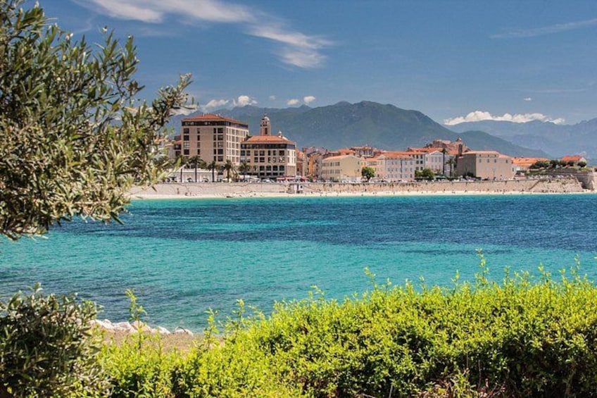 Una cittadina costiera con edifici, una spiaggia e montagne sullo sfondo. 2
