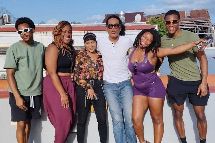 Un grupo de personas de pie en una azotea, con edificios al fondo. 1