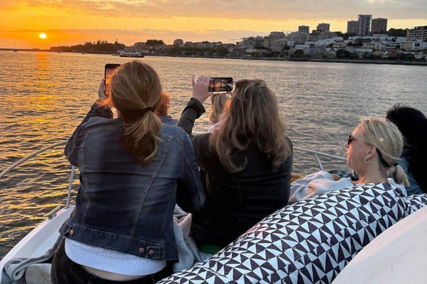 A sunset over a body of water with buildings in the background. 2