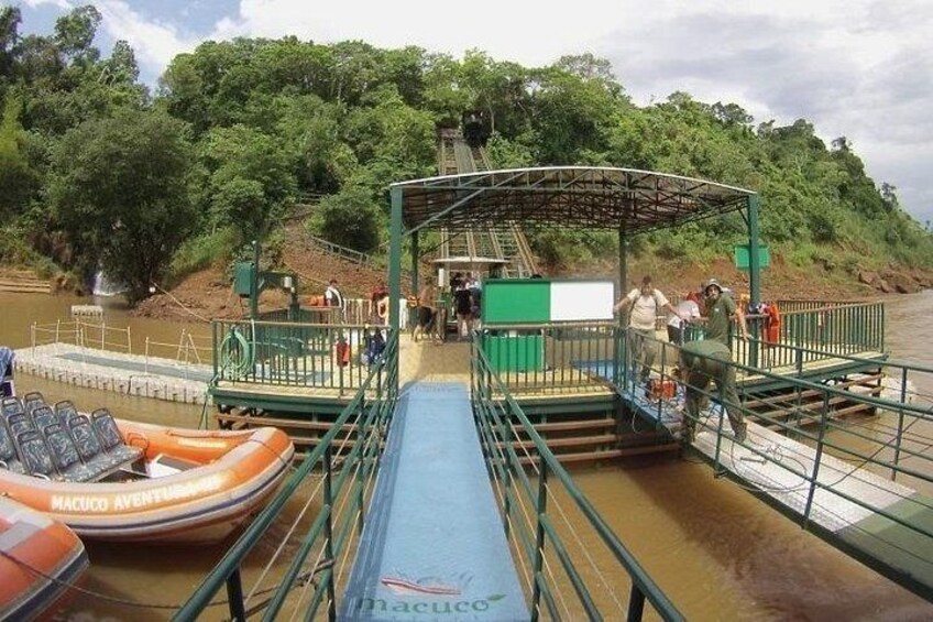 A river with a boat dock, a covered walkway, and a forested hillside. 4
