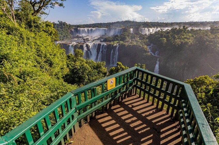 A staircase leading to a waterfall with lush greenery around. 2