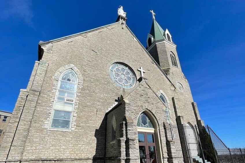 A church with a clock, arched windows, and a steeple. 5