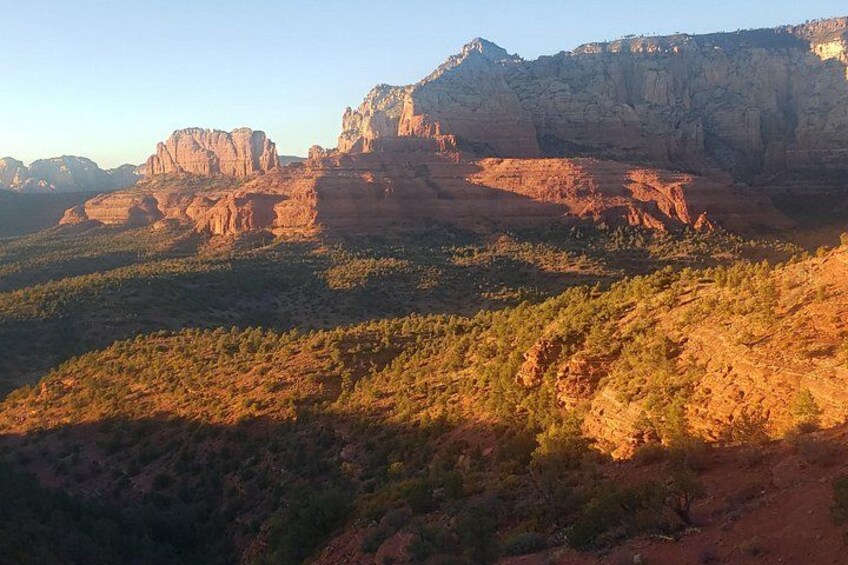 Un paysage désertique caractérisé par des formations rocheuses rouges et une végétation clairsemée. 4