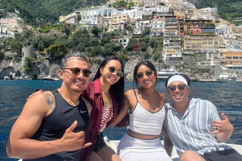 A group of people on a boat with a coastal town in the background. 5