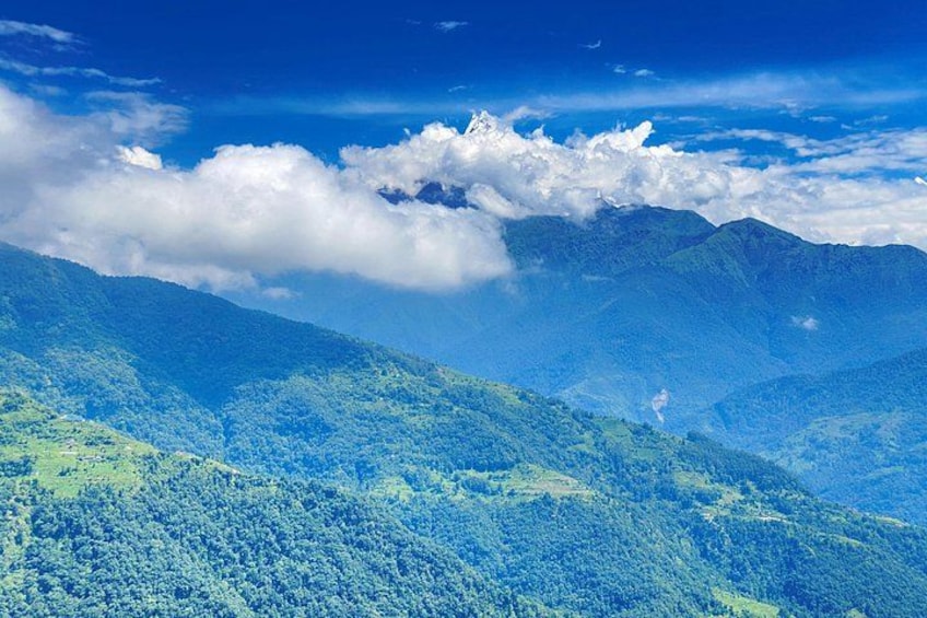 Un paysage montagneux, avec de vastes forêts verdoyantes et un ciel bleu azur. 1