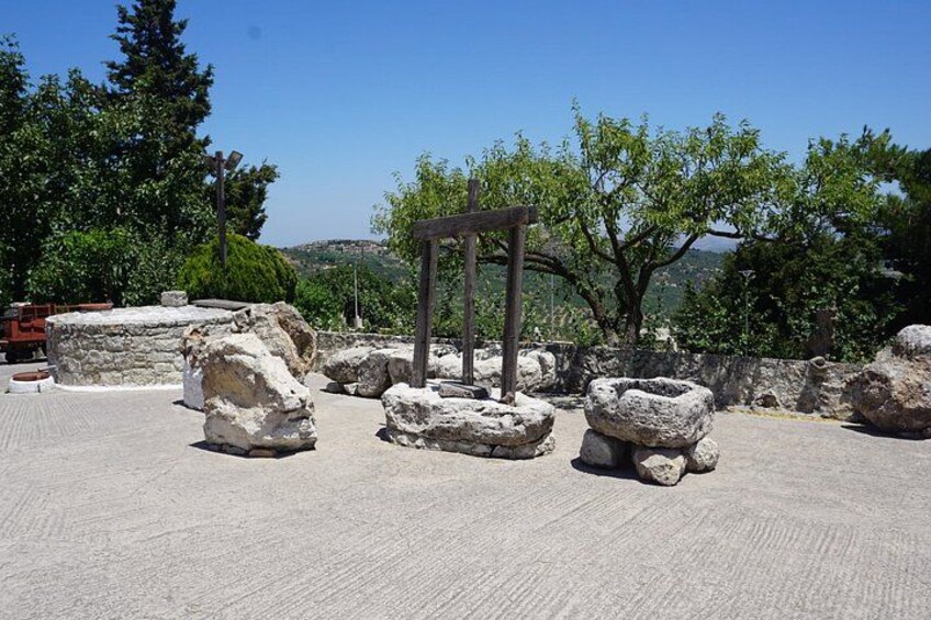 Ancient ruins with stone structures and a wooden archway. 4