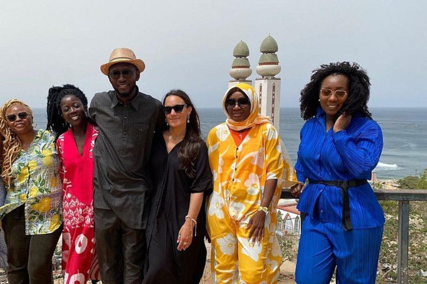 A group of people standing on a coastal overlook with the ocean in the background. 2