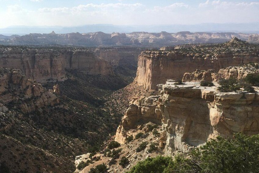 Et canyonlandskab med stejle klipper og sparsom vegetation. 2
