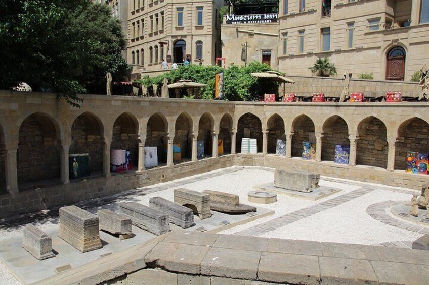 Un antiguo patio de piedra con arcos y una plaza central. 4