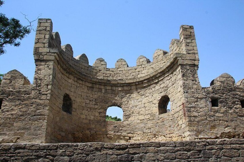 Un arco de piedra con merlones, parte de una estructura de muro de piedra más grande. 2