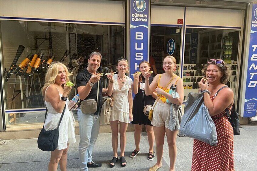 Un grupo de personas frente a una tienda con un letrero que dice "DURBUN DUNYASI BUS". 4
