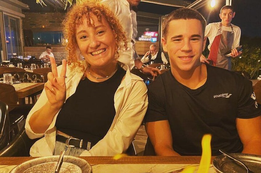 Dos personas sentadas a una mesa con un vaso y una servilleta. 2
