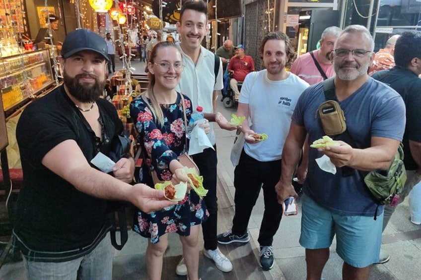 Un grupo de personas en un mercado rodeado de productos alimenticios. 3