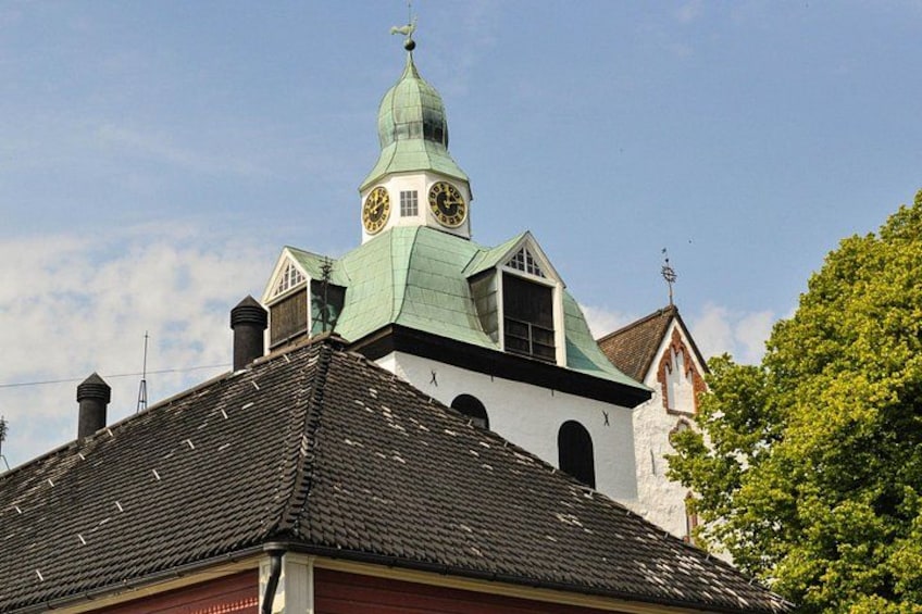 A church with a green dome and a clock tower. 4