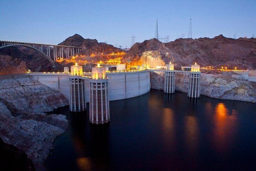 A dam with water gates, a bridge, and a mountainous backdrop. 4