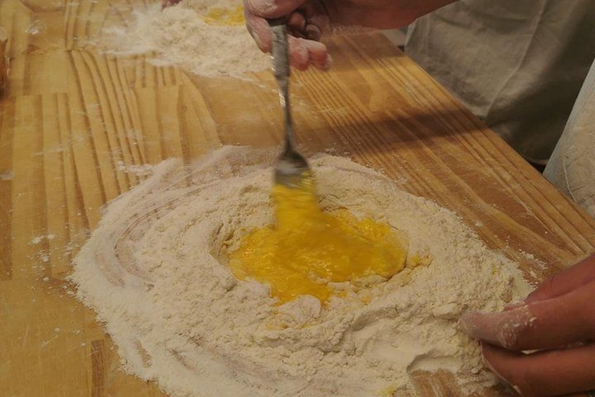 Una persona mescola ingredienti su un piano di legno. 2