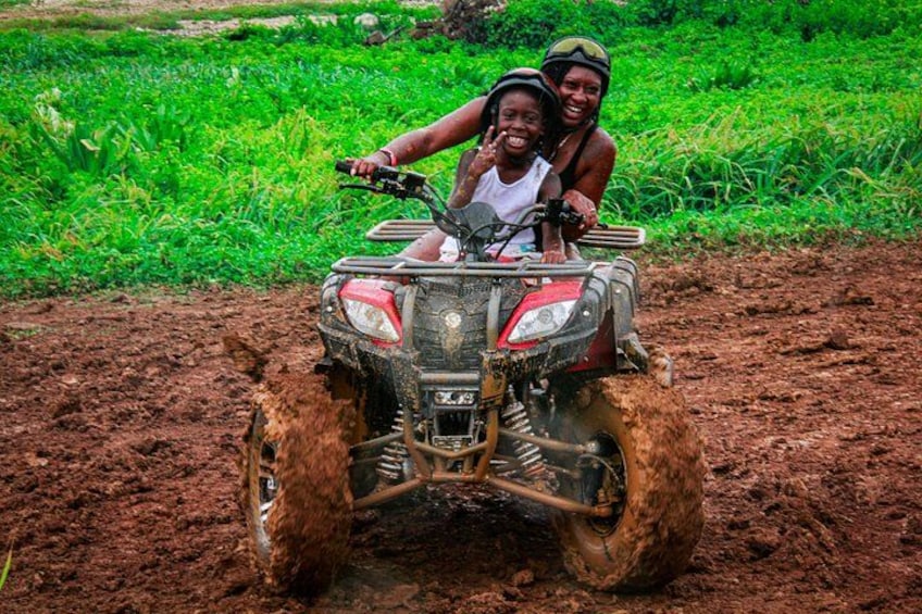 A person riding a four-wheeled vehicle through a muddy field. 3