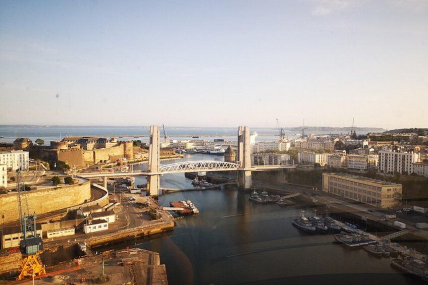 A bridge spanning a river, a port with boats, and a cityscape with buildings. 4
