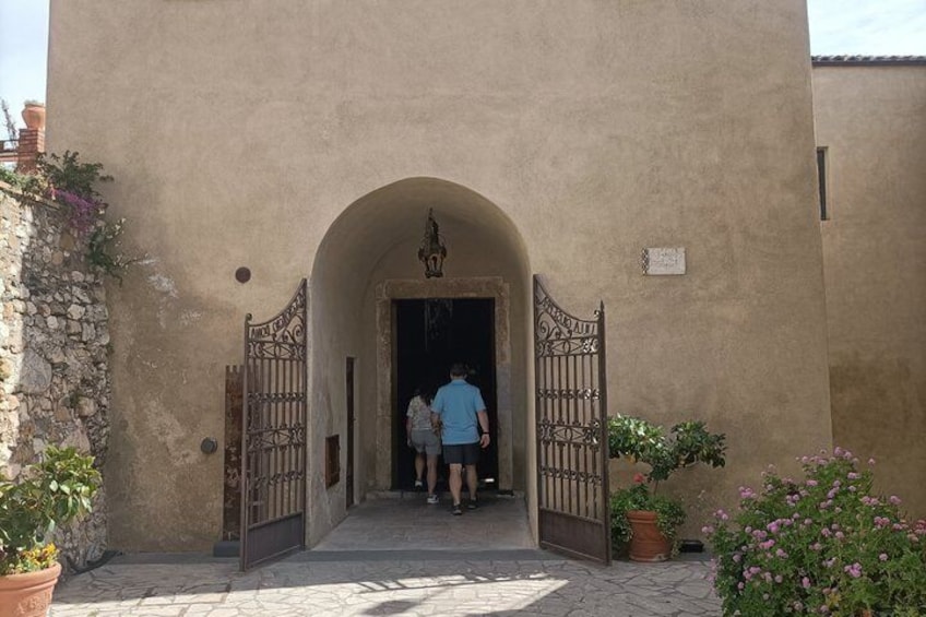 Une entrée d’immeuble avec un mur en pierre, un portail en métal et des plantes en pot. 5