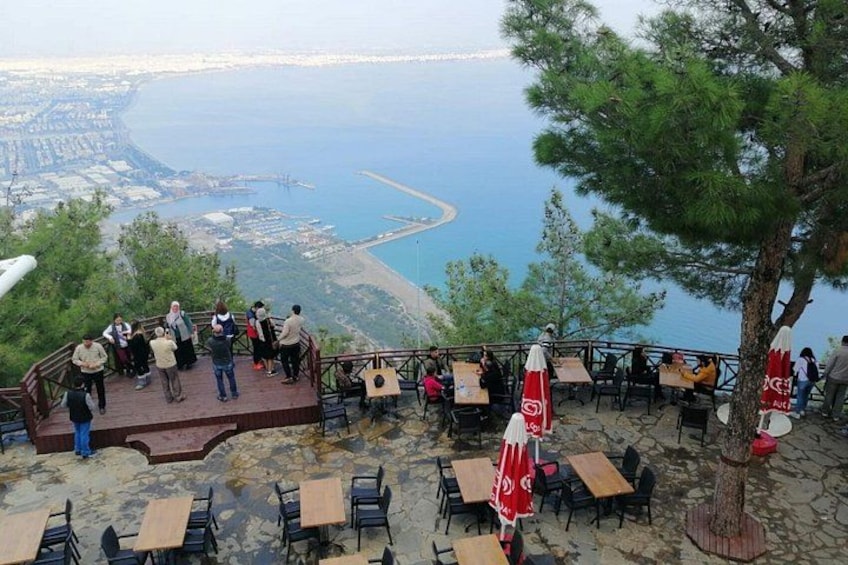 A terrace with tables and chairs overlooking a coastal view. 3