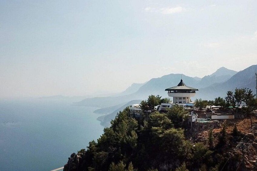 A pagoda on a hill overlooking a coastal area with mountains in the background. 5